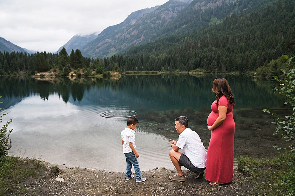 Family skipping rocks during Gold Creek Pond maternity photo session