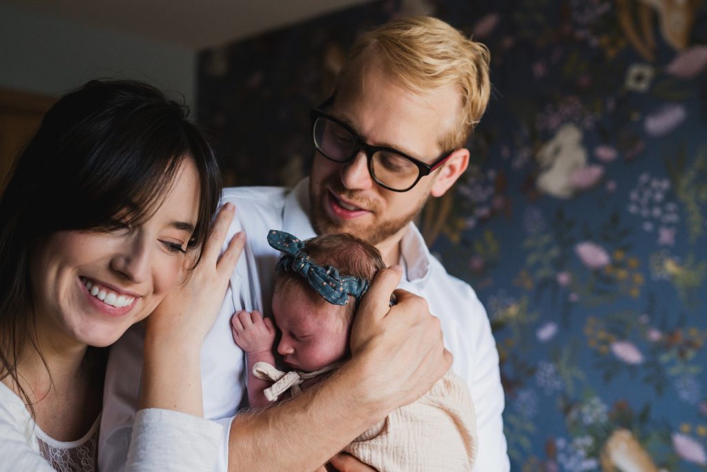 Family of three loving on newborn baby during Seattle newborn photography session