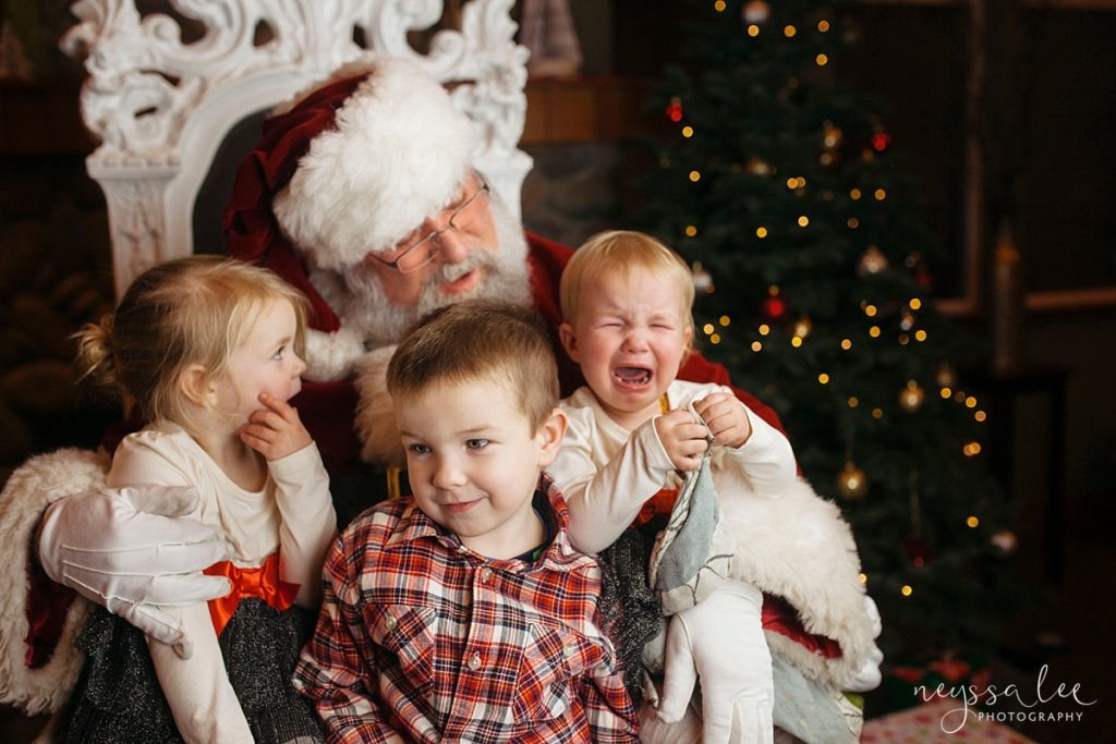 Crying toddler in Santa's lap with two siblings for Snoqualmie Santa Photos