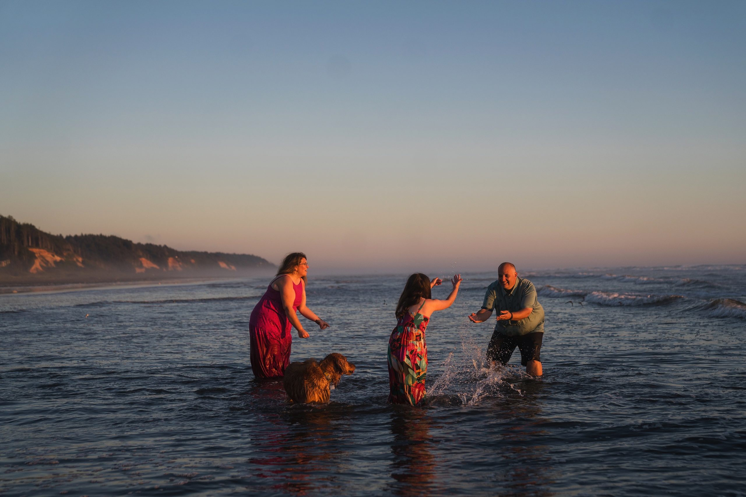 family with dog playing in the ocean at Seabrook WA during family photos
