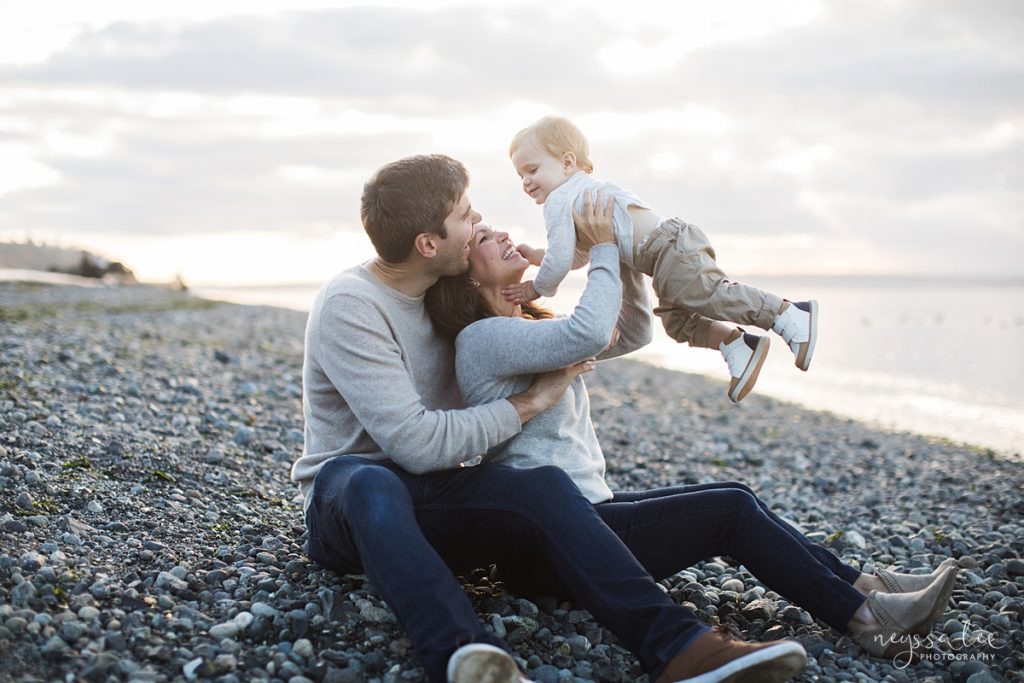 Family of three on the beach at carkeek park for family photos in Seattle