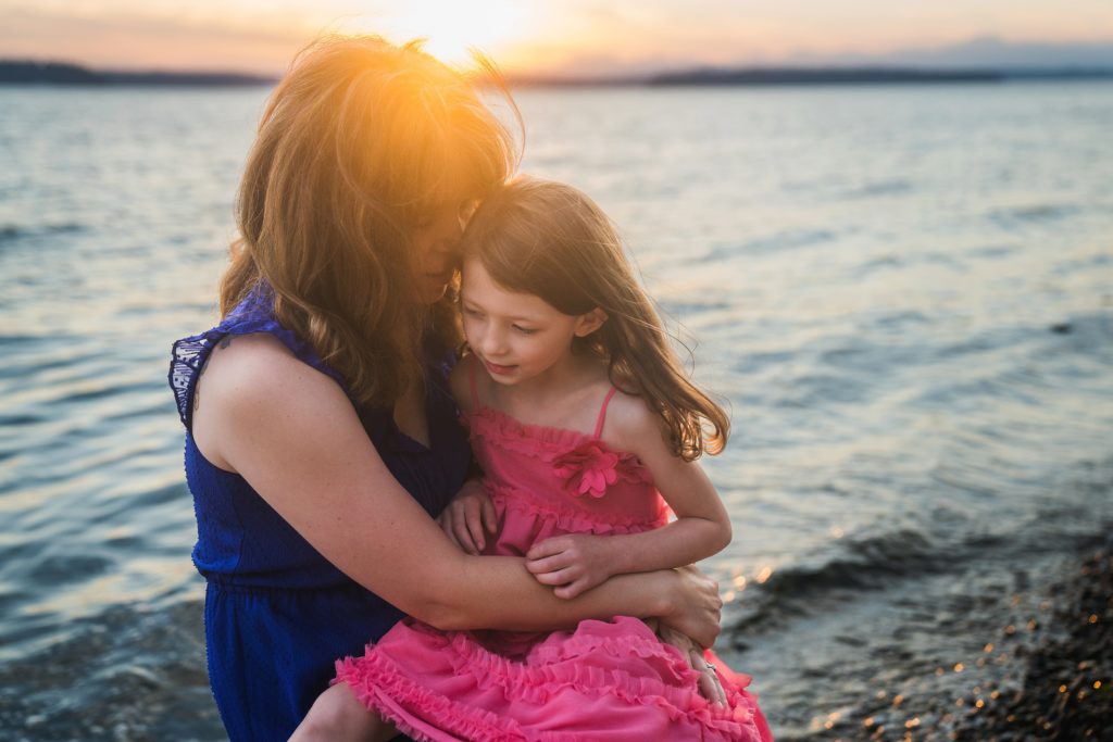 Mother and daughter by the water at sunset for family photos at Lincoln Park, West Seattle