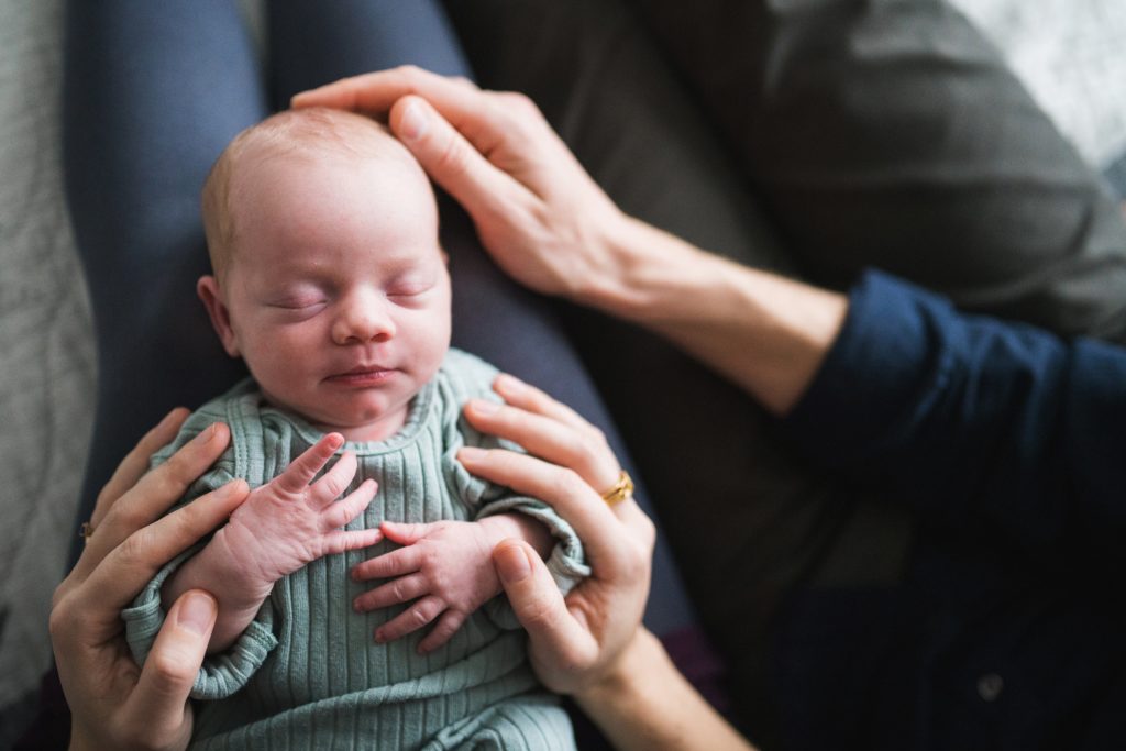 Hands surrounding newborn baby