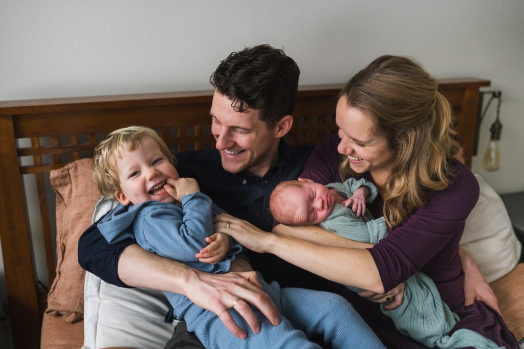 Mom, dad, toddler boy and newborn baby girl for newborn photos at home