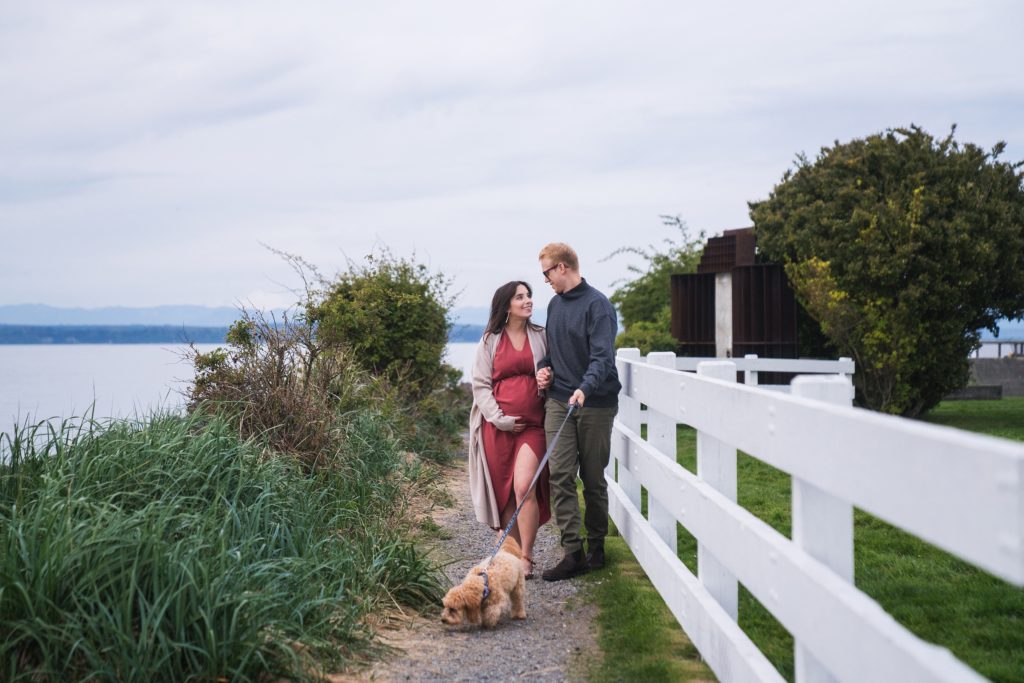 Expecting couple walking together with dog during Seattle area maternity photos