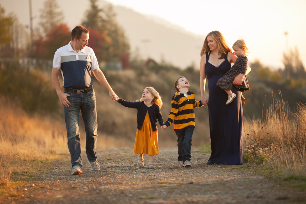 Family of 5 walking on sunlit path dressed in navy and mustard yellows
