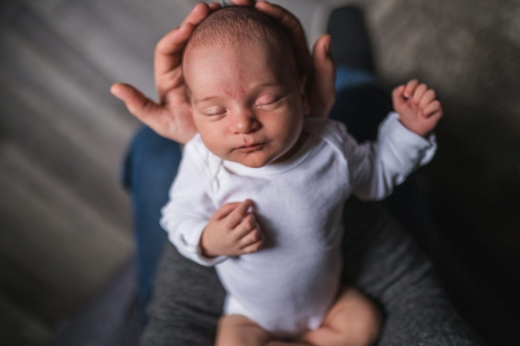sleeping baby in dad's arms during Seattle newborn family photoshoot