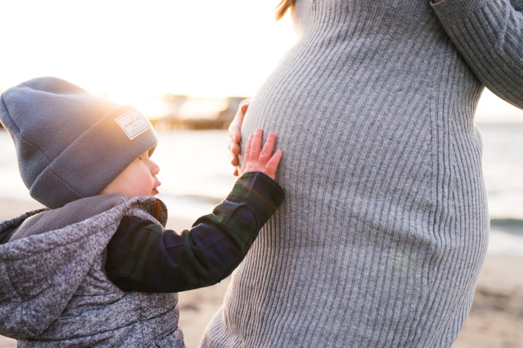 Toddler boy touching mom's pregnant belly during Seattle maternity photos