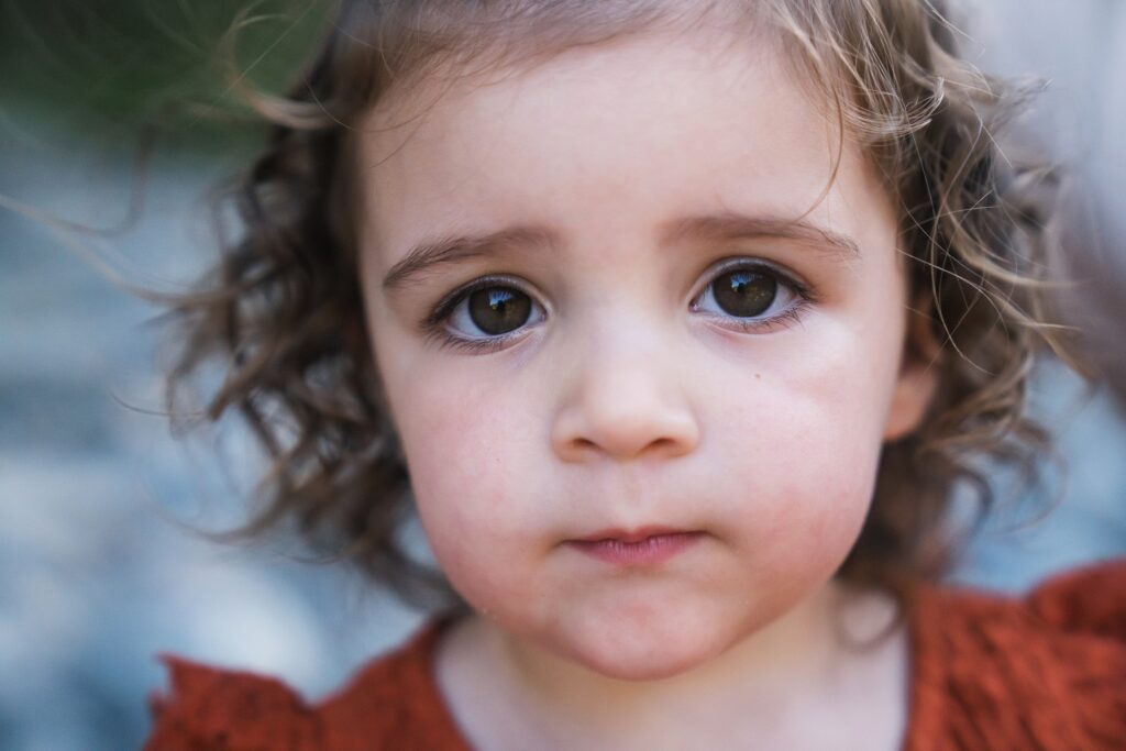 Girl with big, dark brown eyes and curls staring into the camera during Seattle area photography session