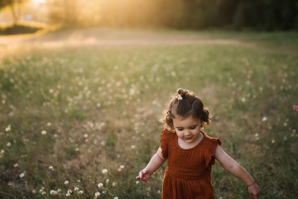 Girl running in field of dandelions at Tanner Landing Park 
