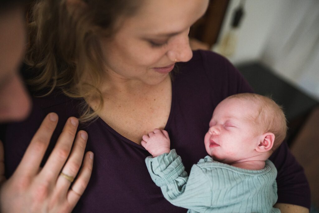 Mother holding newborn baby girl against her chest during Seattle portrait session