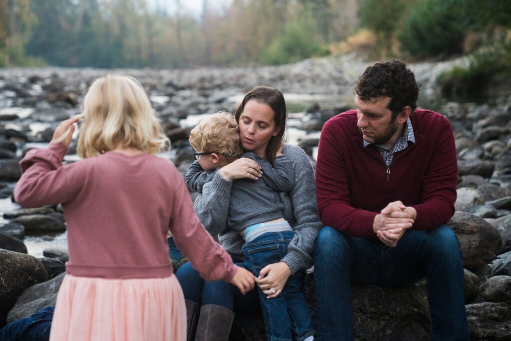 Mother embracing son surrounded by family during photos in Seattle area