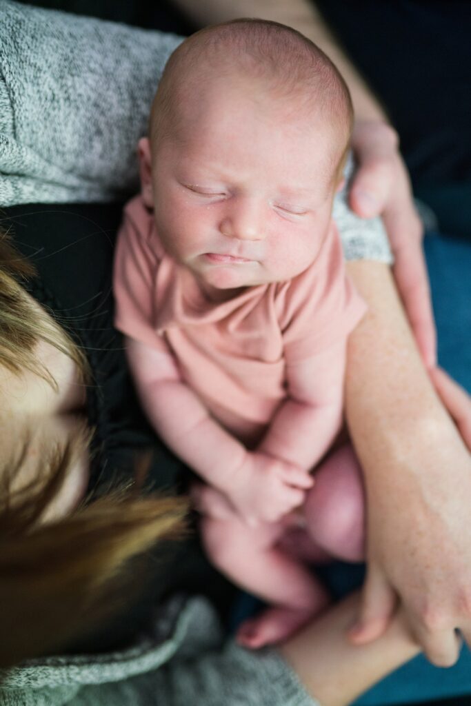 Baby in mother's arms during in-home Seattle portrait session