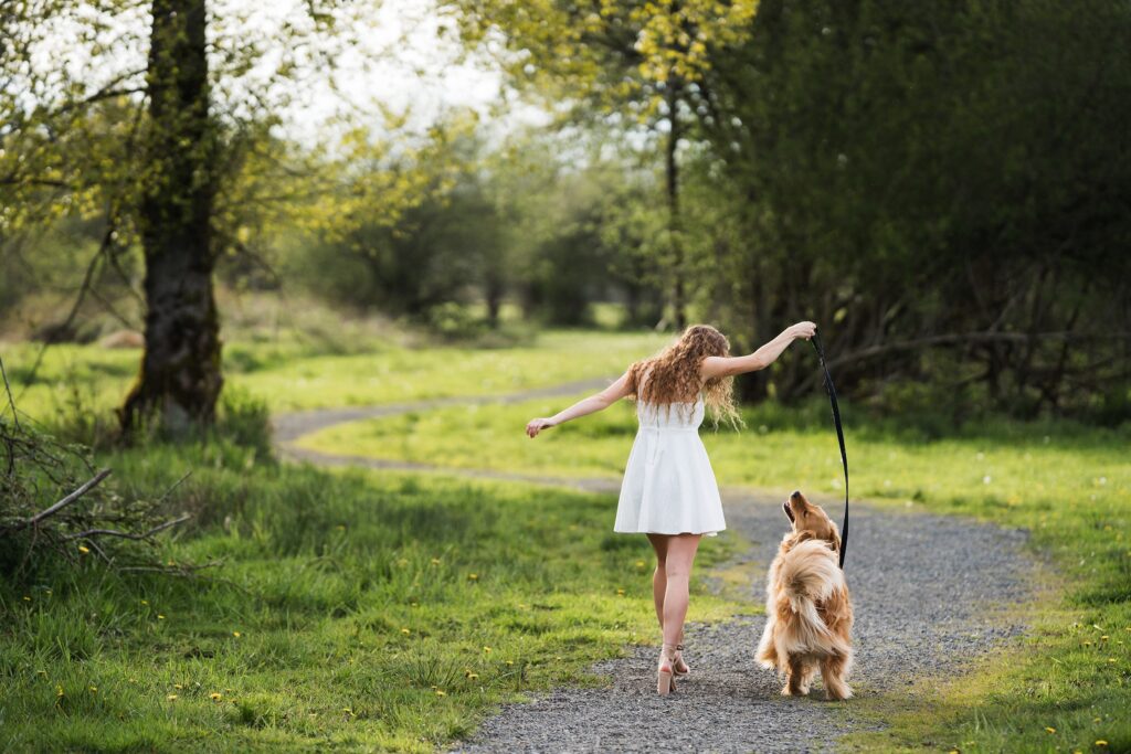 Young woman walking with golden retriever at Meadowbrook Farm, North Bend, WA