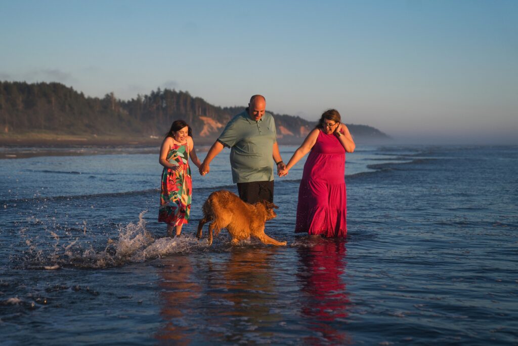 Golden retriever in the ocean during Seabrook portrait session with mom, dad, and little girl