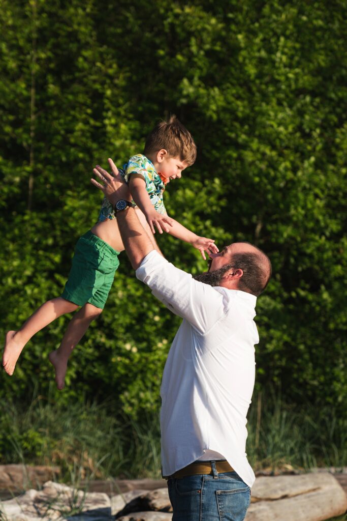 Father tossing son into the air playfully for photos