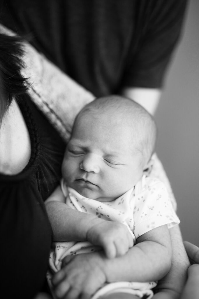 Black and white photo of baby girl in mother's arms for professional newborn photos in the greater Seattle area.