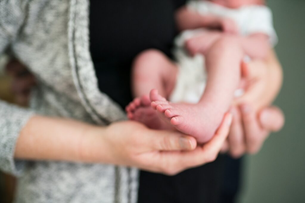 Mother holding newborn baby girls' feet lovingly during Snoqualmie newborn photos