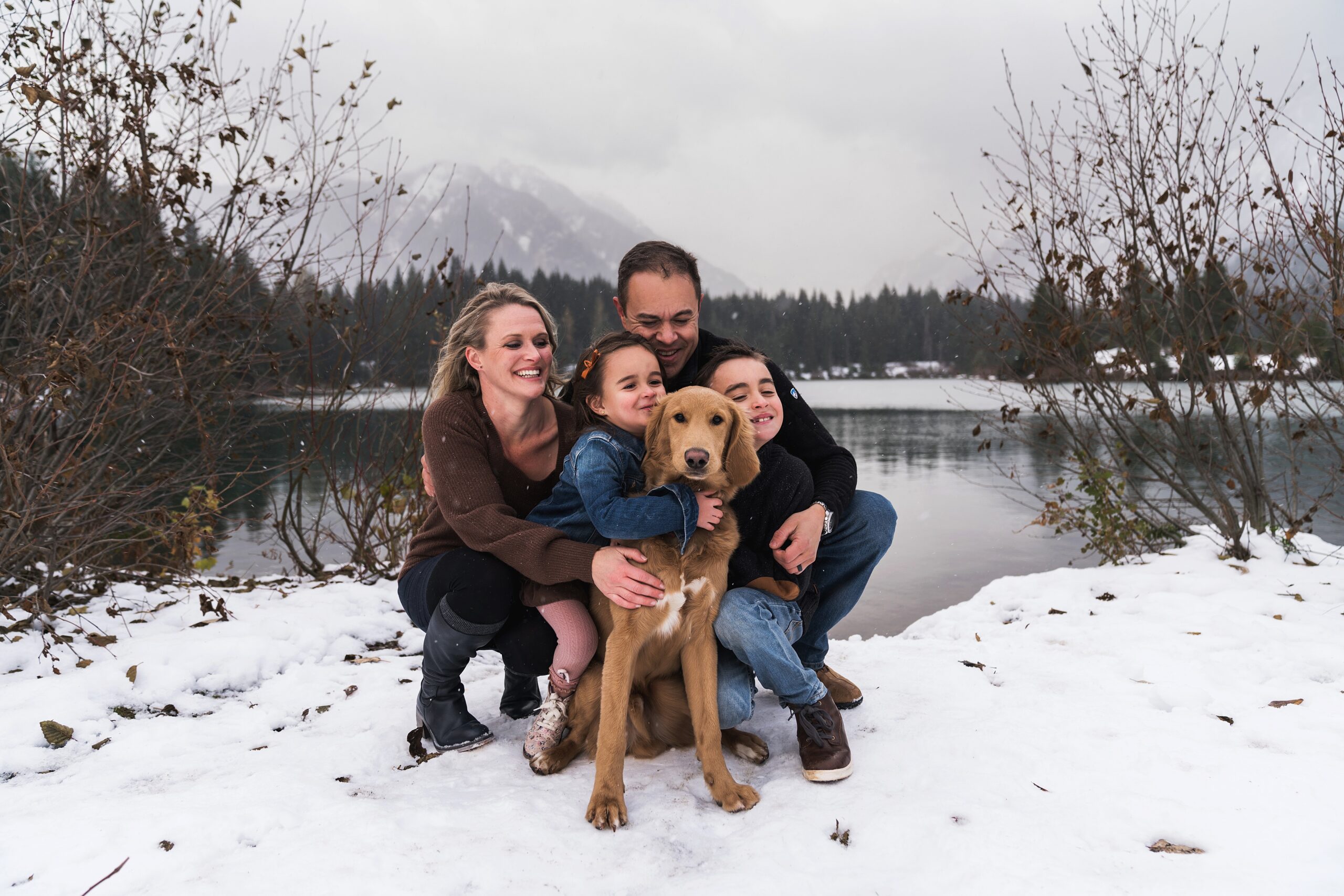 Family with dog at Gold Creek Pond for photos in the snow