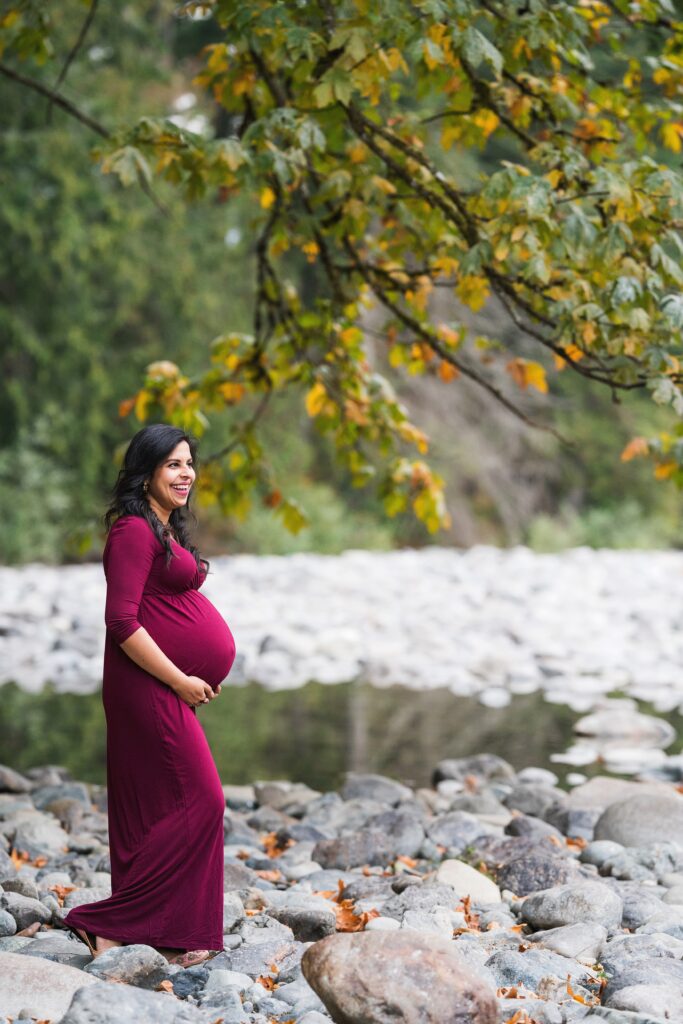 Maternity picture of an expectant mother standing by the river in Snoqualmie