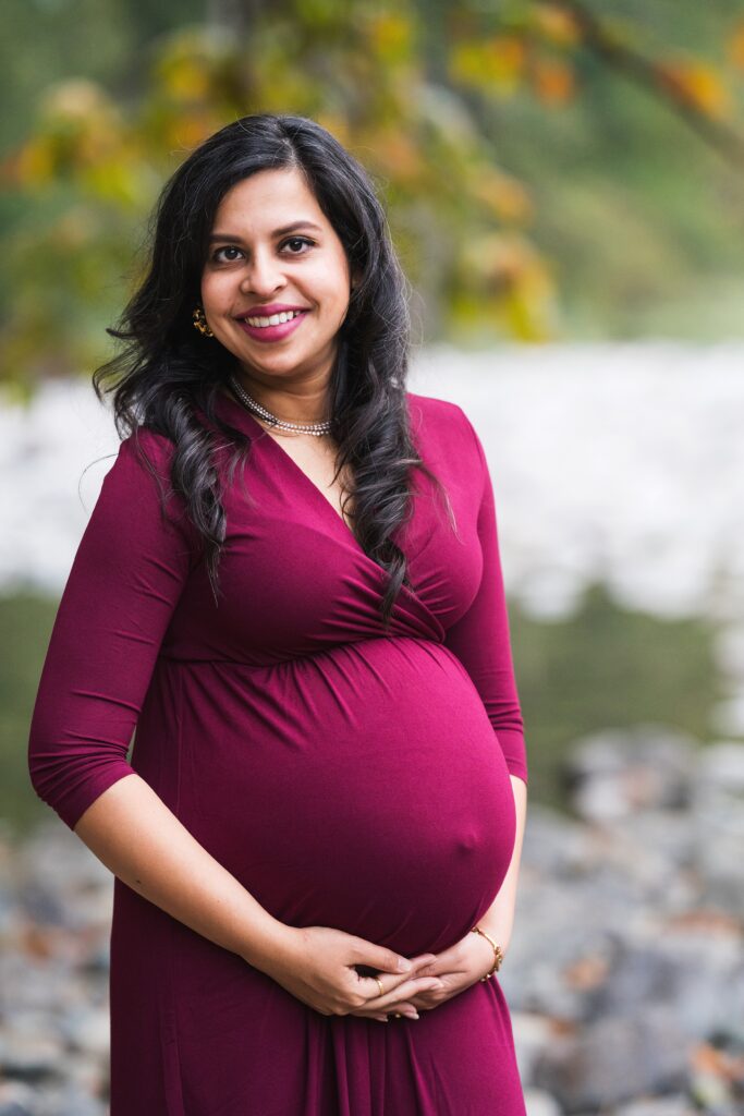 Pregnant woman in a deep maroon dress during maternity photos in Seattle area, 