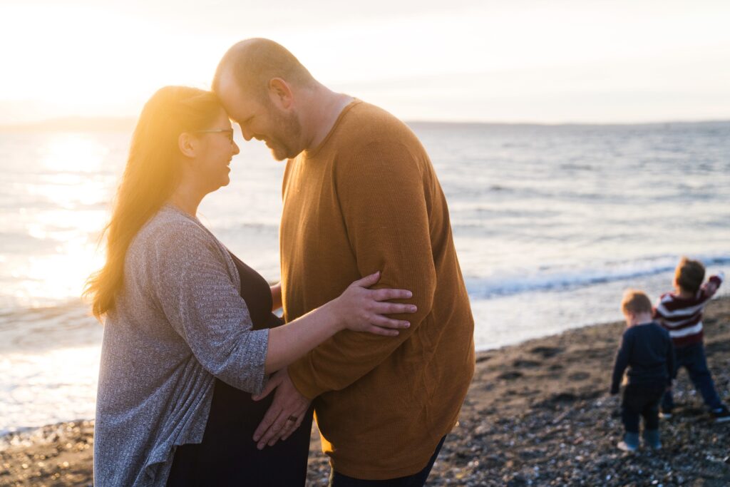 Husband and wife during maternity photos at the beach in Edmonds, WA