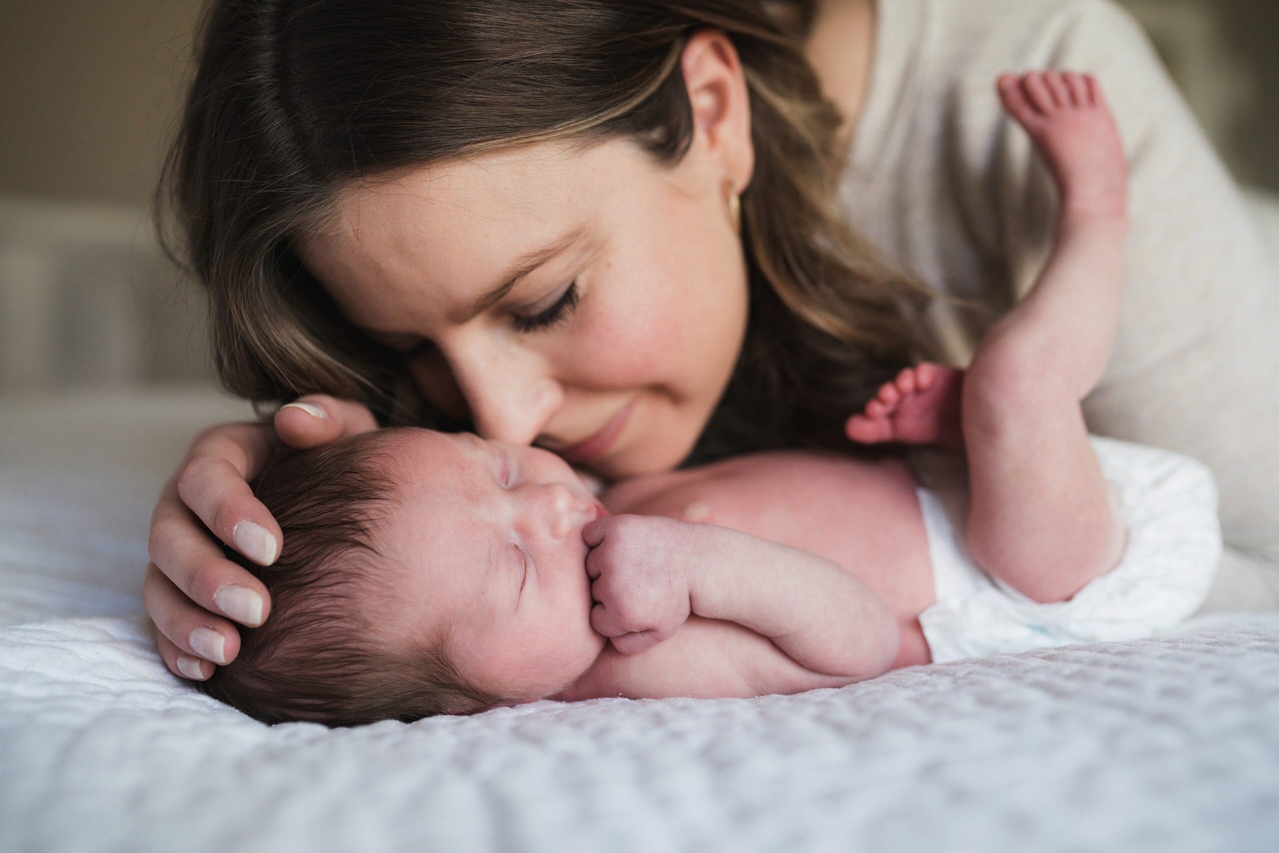 Mother loving on baby girl during newborn photography session