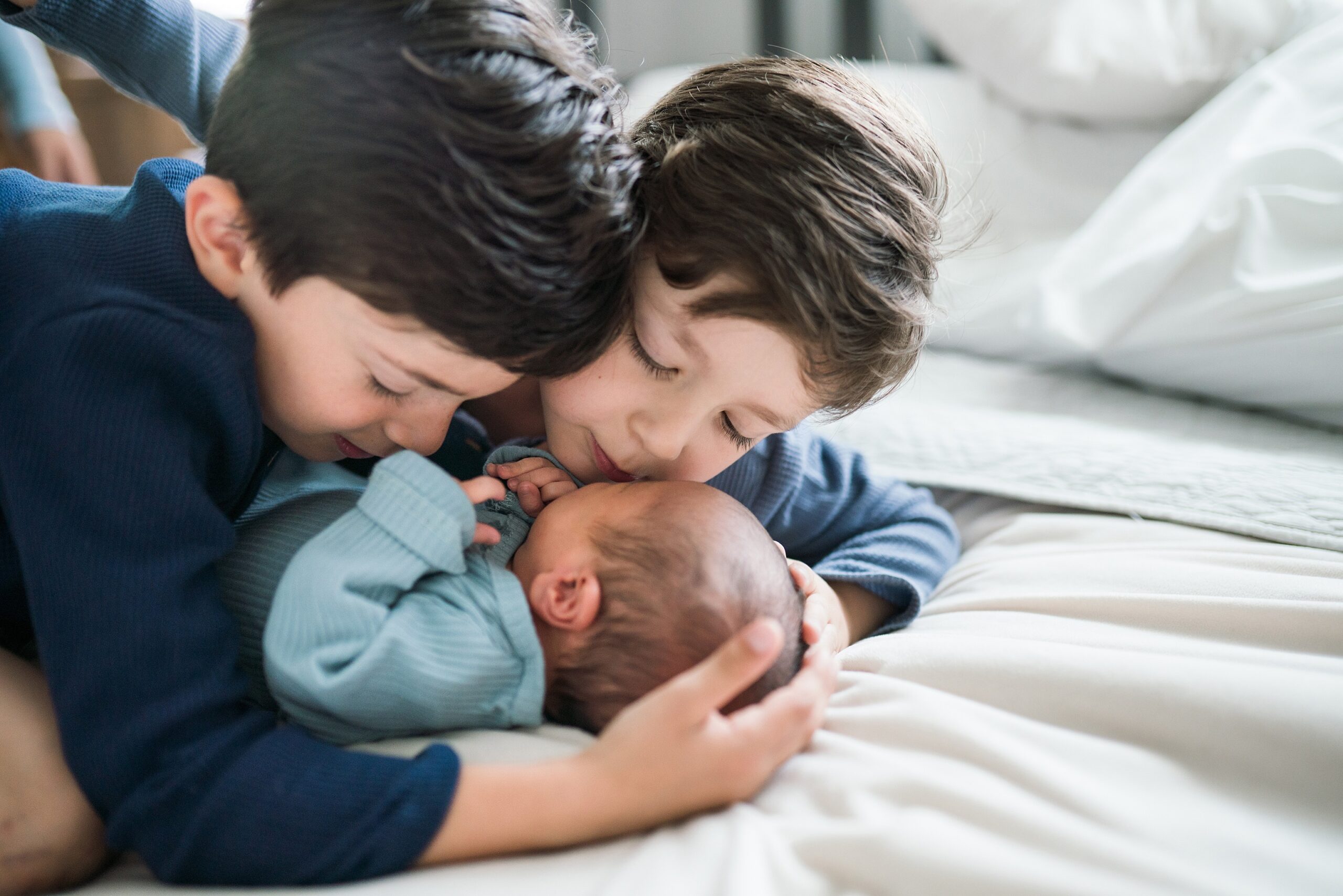 Sibling portraits during newborn photo session, 2 brothers snuggling newborn baby brother