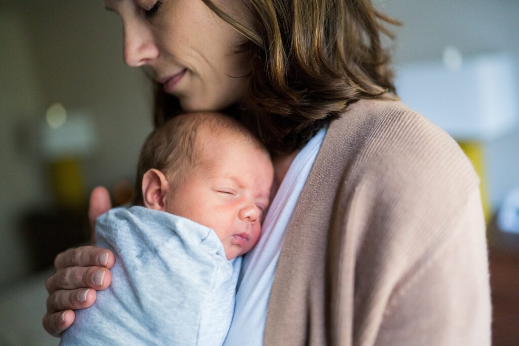 Swaddled newborn in mother's arms during North Bend Newborn Portrait Session