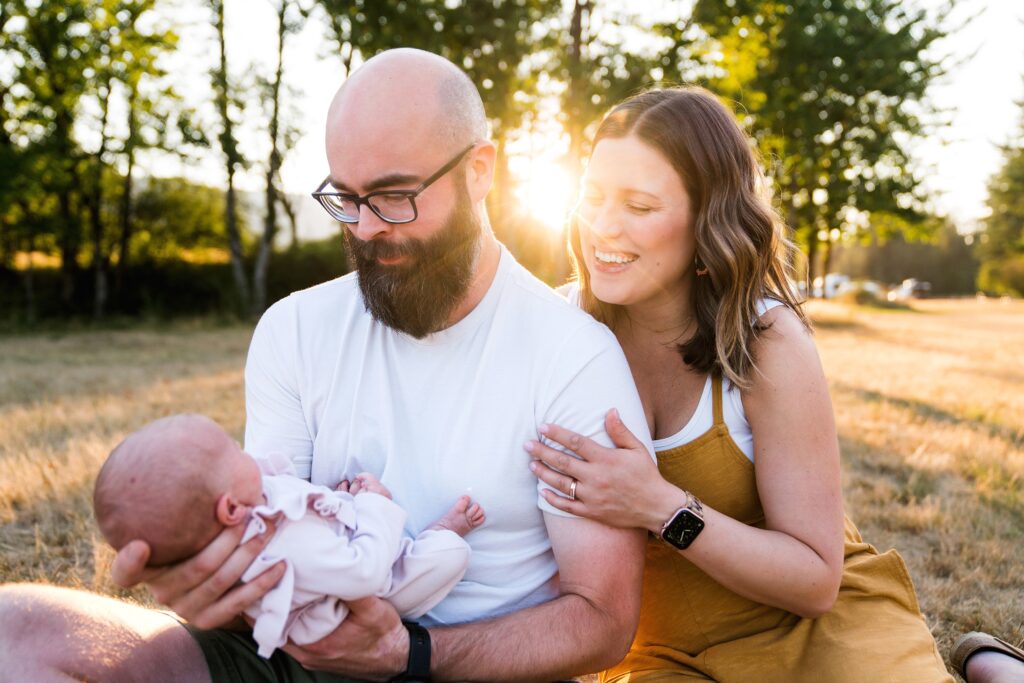 Parents admiring baby girl during Tanner Landing Park newborn photo session