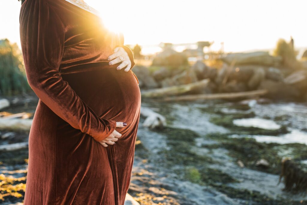 Sunlight surrounded baby bump of pregnant mother during Seattle maternity photos