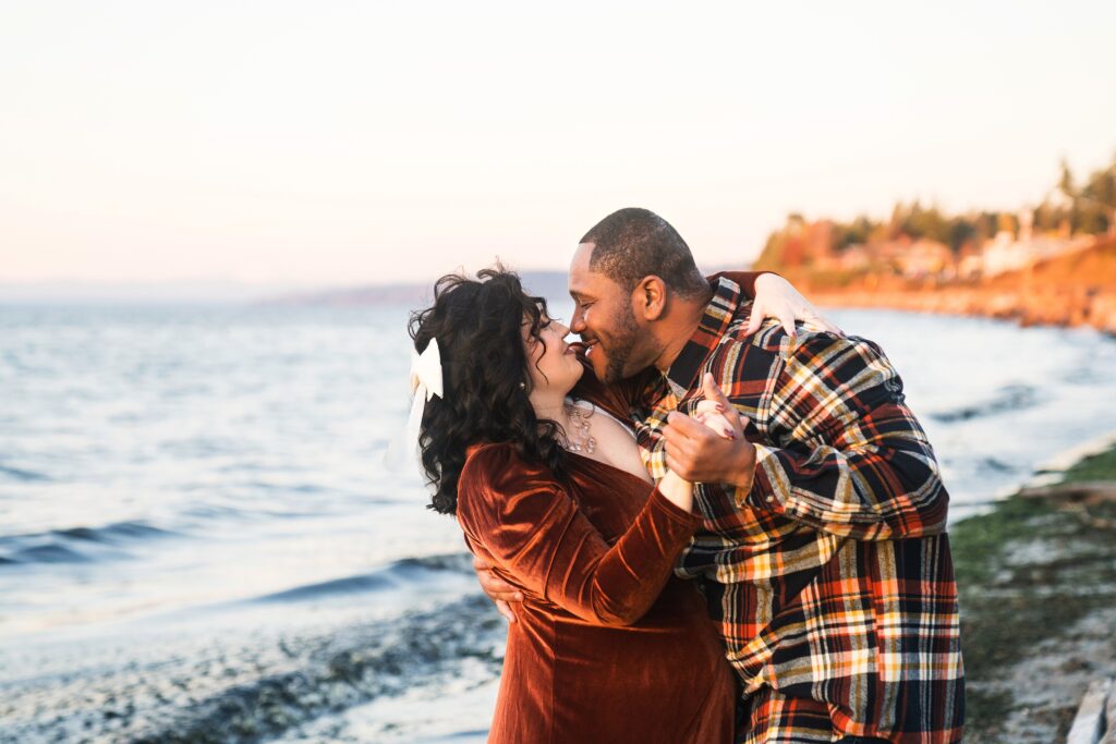 Husband and wife dancing during maternity photos on the Seattle beach