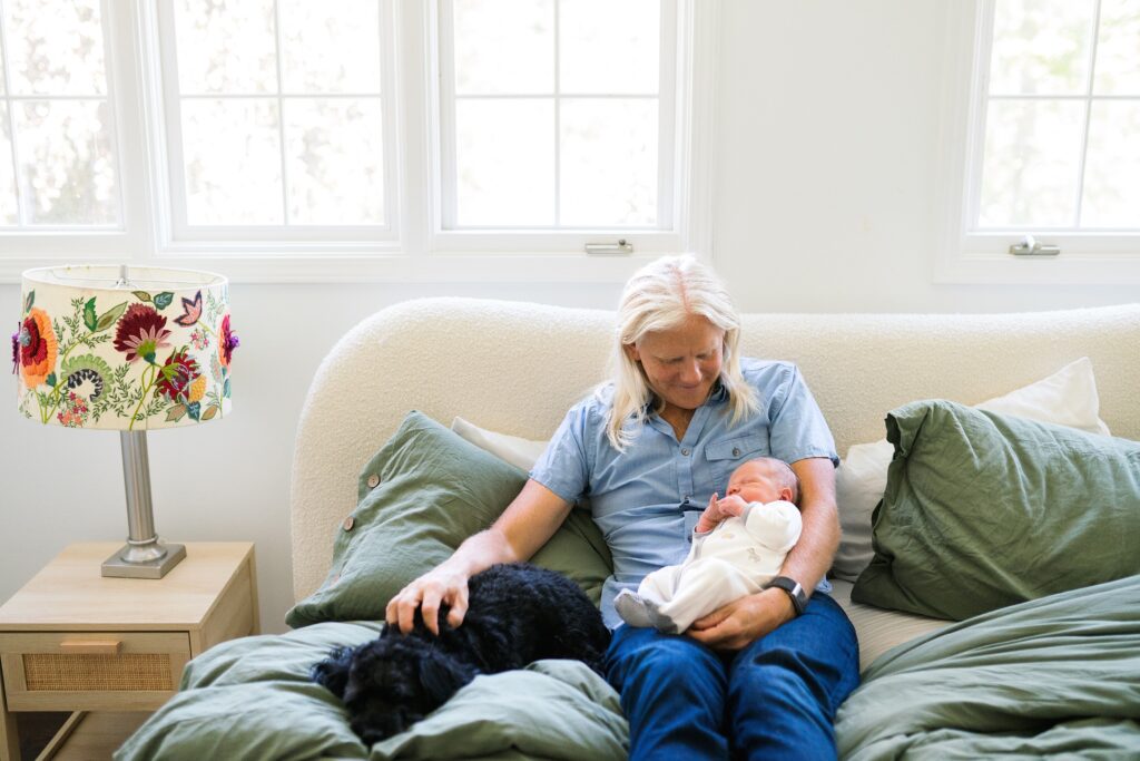 Father and son on master bed with puppy dog nearby 