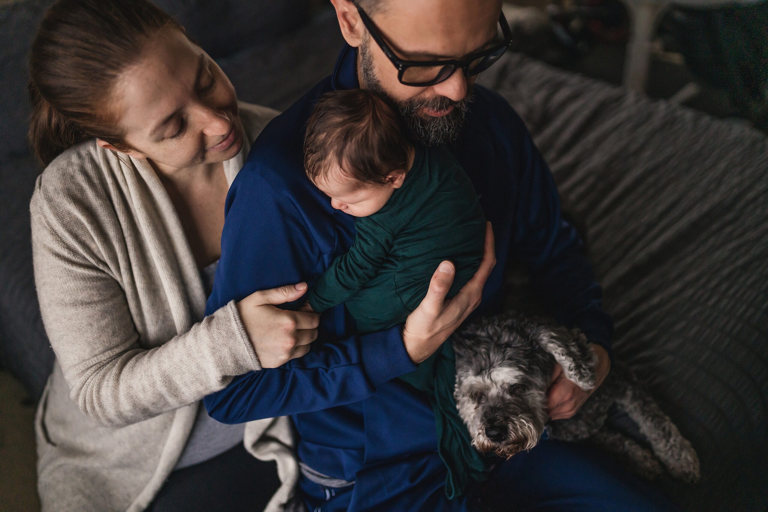 Seattle in-home lifestlye newborn photo of family snuggled with baby and dog