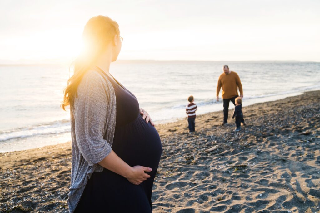 Mother with layers for maternity photos on the beach in Seattle