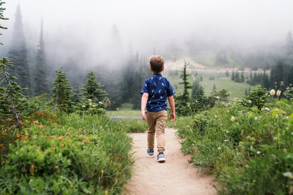 Boy walking down trail towards Tipsoo Lake during family photos on Mount Rainier