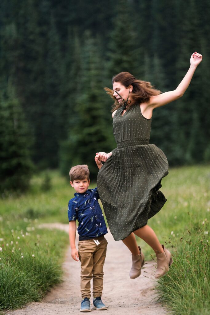 boy and mother holding hands while mother jumps, Mount Rainier Family Photos