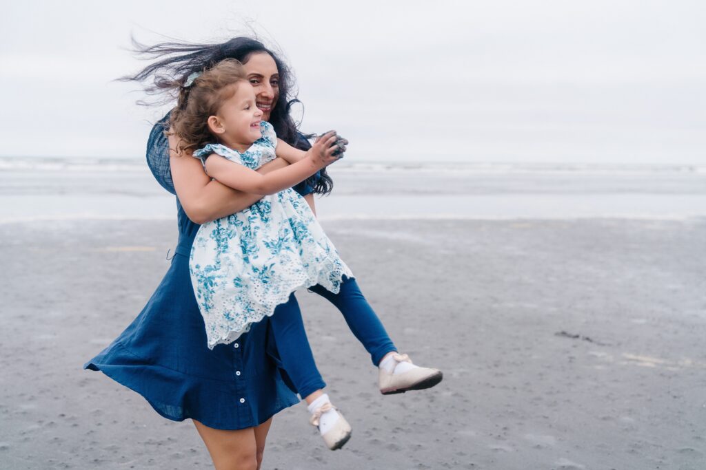 Mother twirling with daughter on the beach in Seabrook