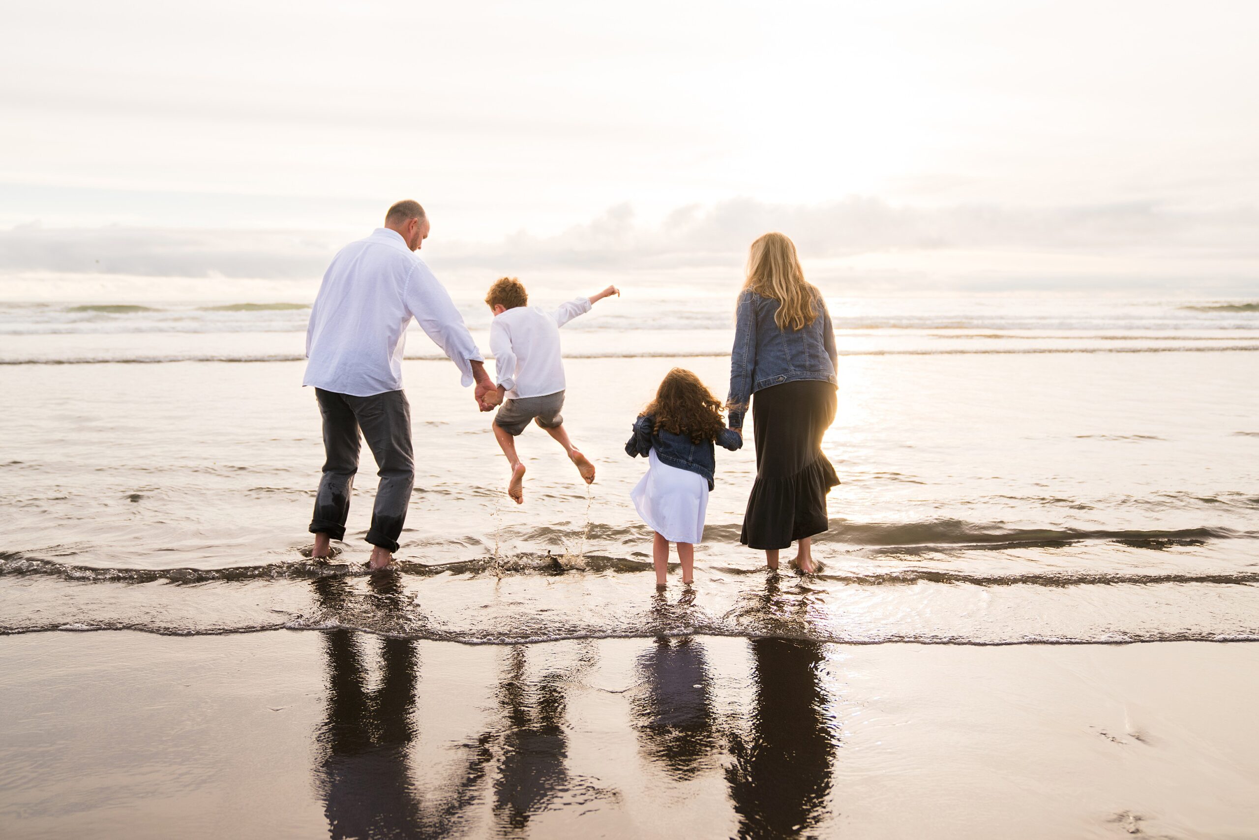 Family jumping waves at the beach at sunset, Ocean Shores, Wa