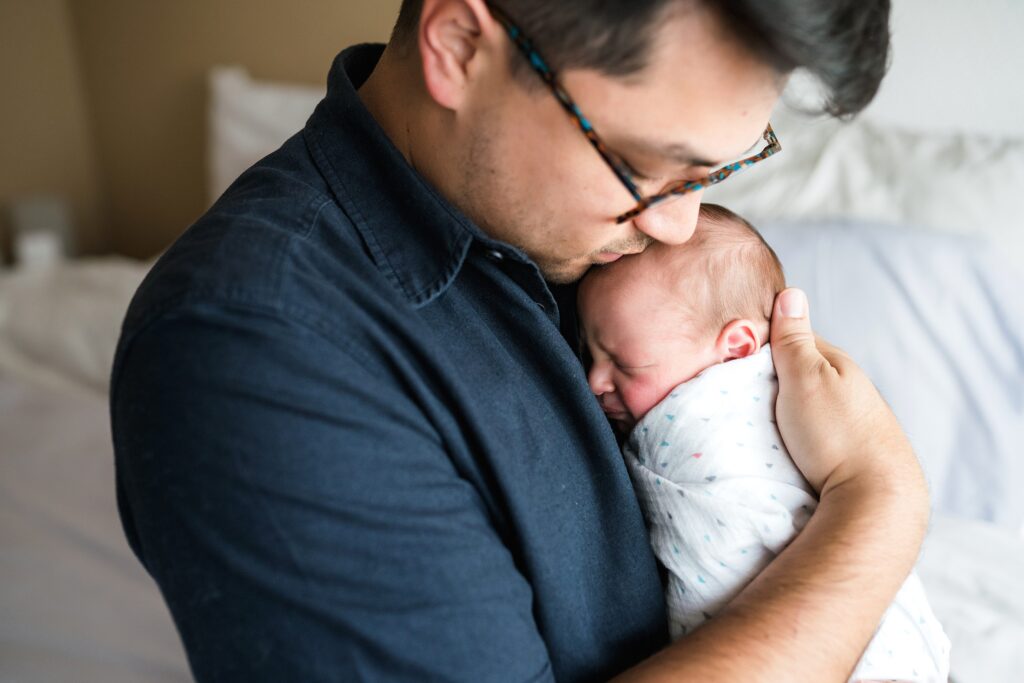 Father holding swaddled baby during Seattle portrait session