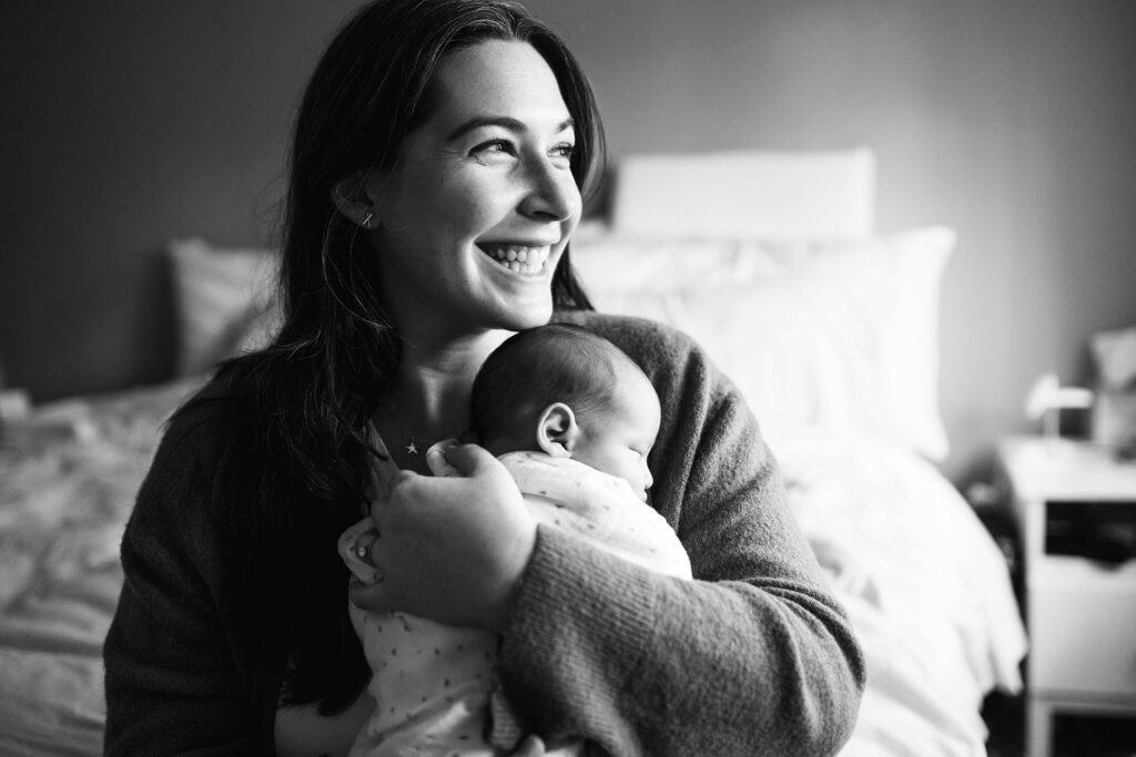 Black and white photo of mother with newborn baby during in home photo session