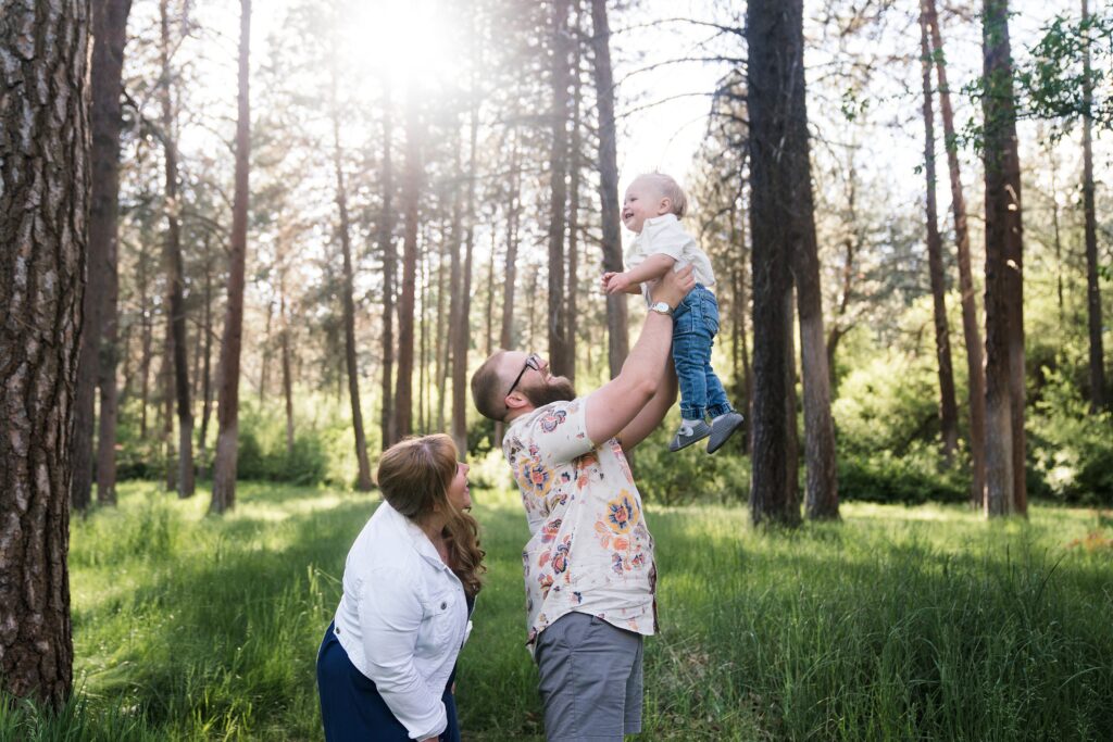 Dad lifting toddler boy into the air during Seattle family photo session