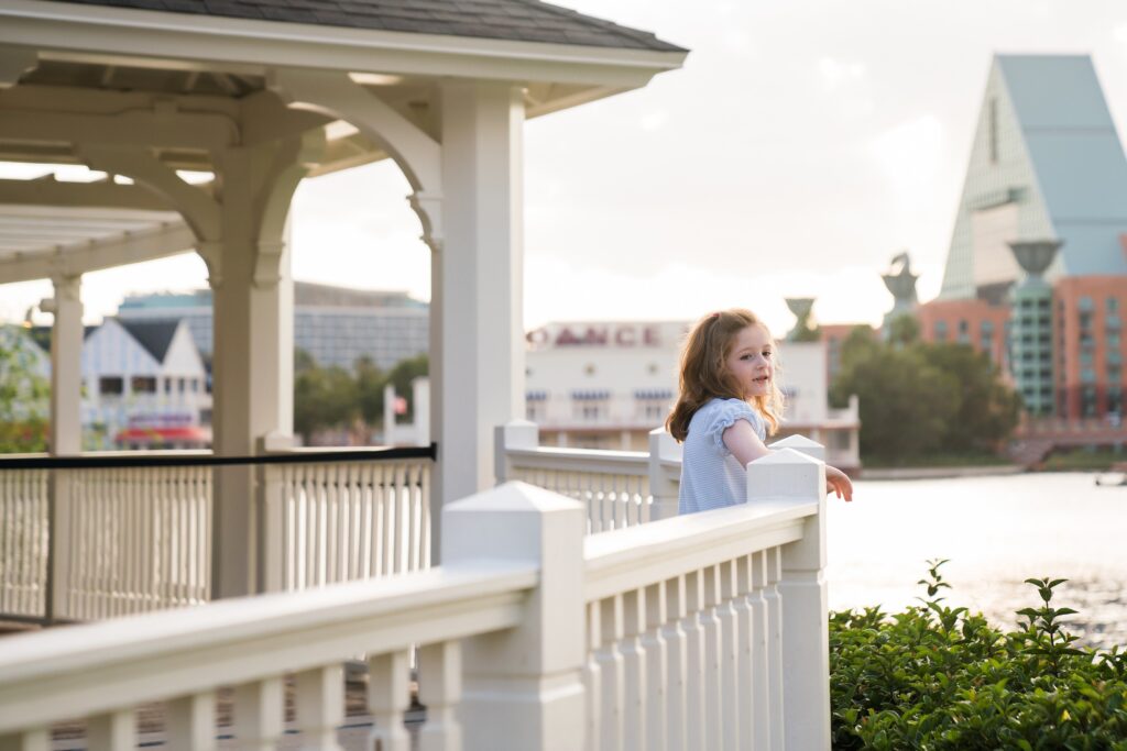 Girl at Disney's Boardwalk for family photos, Swan and Dolphin hotel nearby