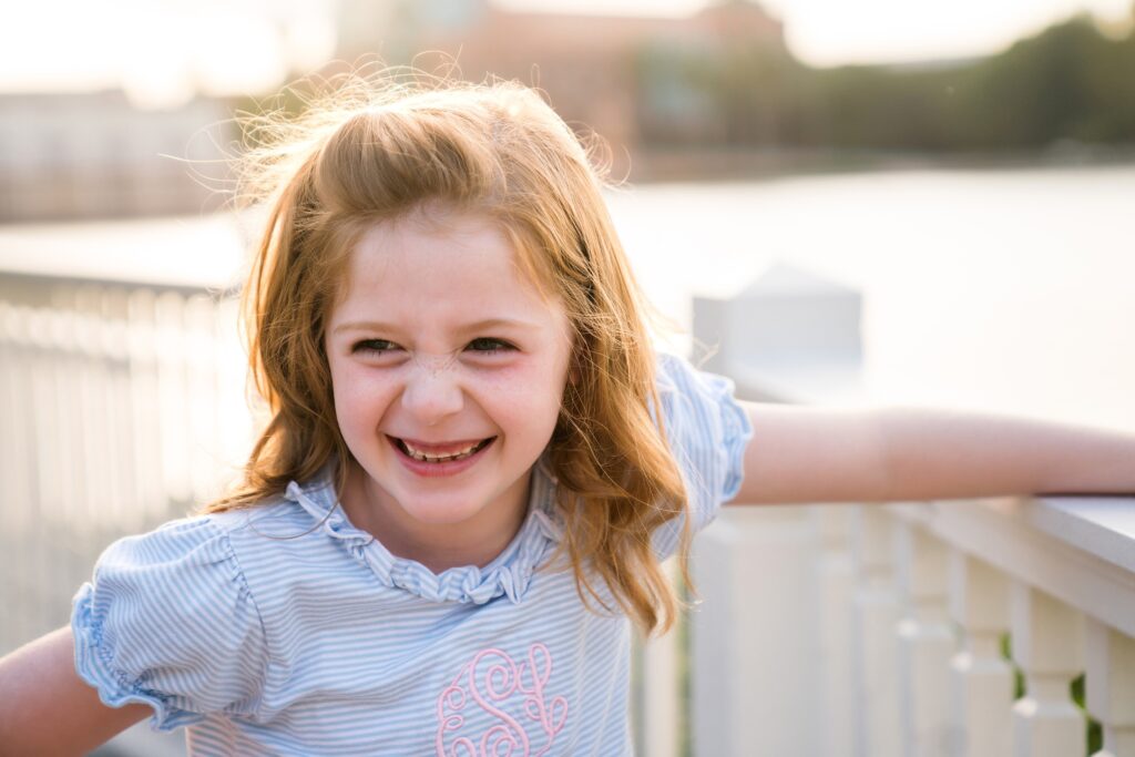 Golden hour photo of laughing girl at family photoshoot at Disney's Boardwalk