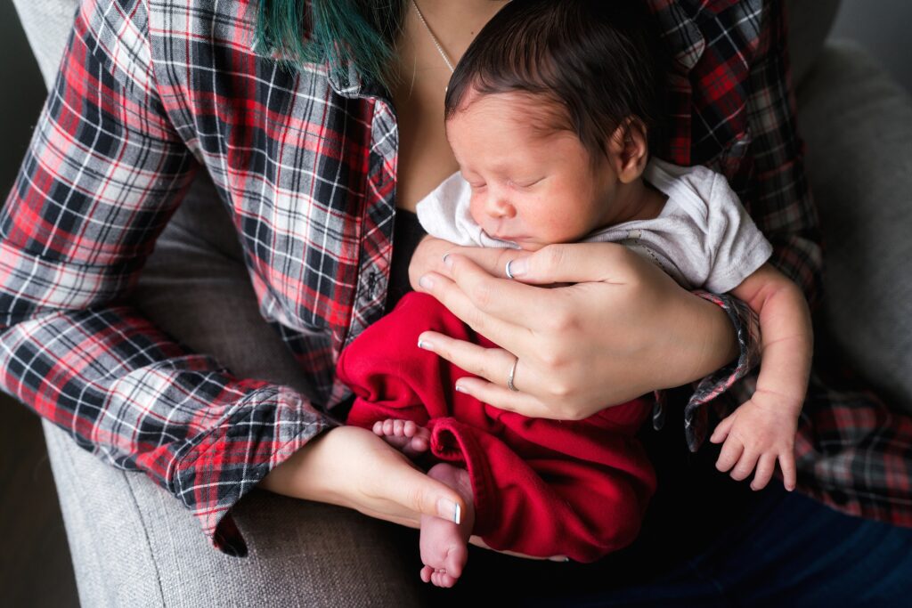 Newborn baby boy in moms arms during in home photoshoot in Seattle area