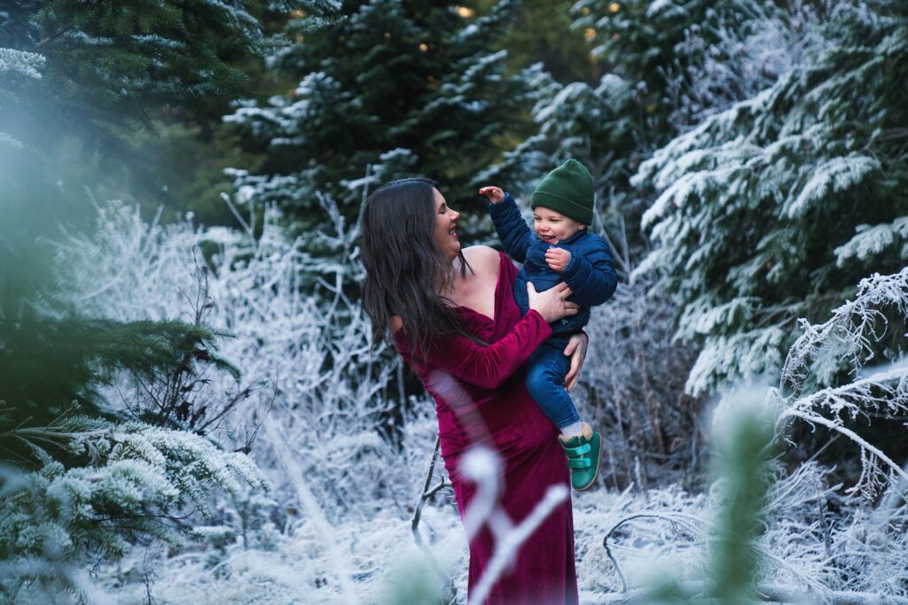 Winter maternity photo as inspiration of what to wear for maternity pictures, woman holding son on the frosty Snoqualmie Pass