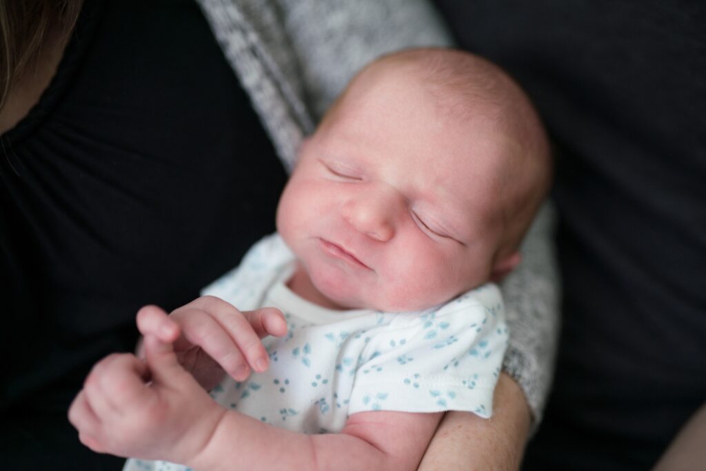 Newborn baby girl in simple white onesie for portraits