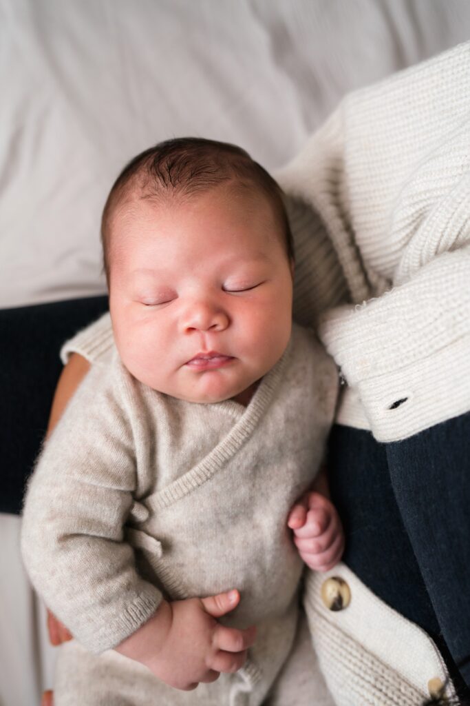 Photos of a newborn baby boy sleeping in mother's arms during Snoqualmie newborn portrait session