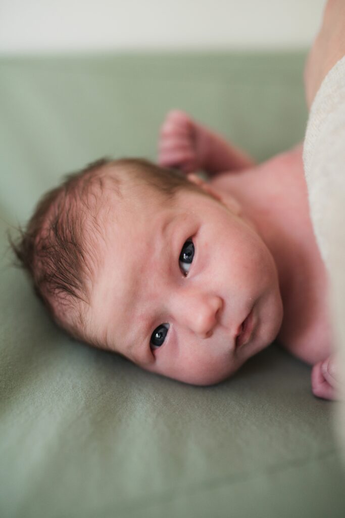 Awake baby girl on changing pad in Snoqualmie Valley home nursery