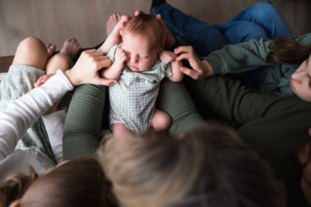 Family loving on newborn baby girl during in-home portraits
